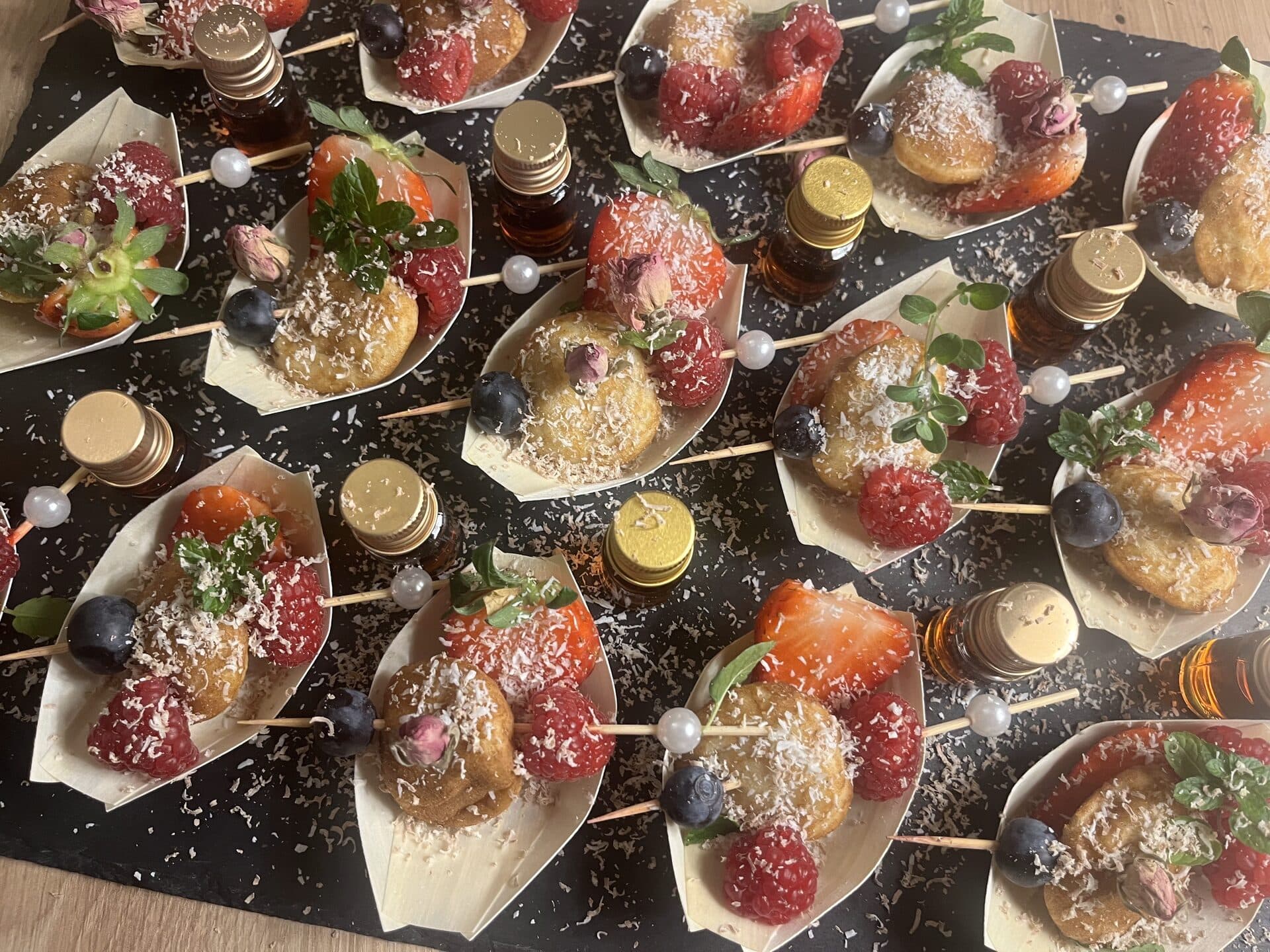 Dessert-Spieße mit Beeren, Kokosraspeln und essbaren Blüten