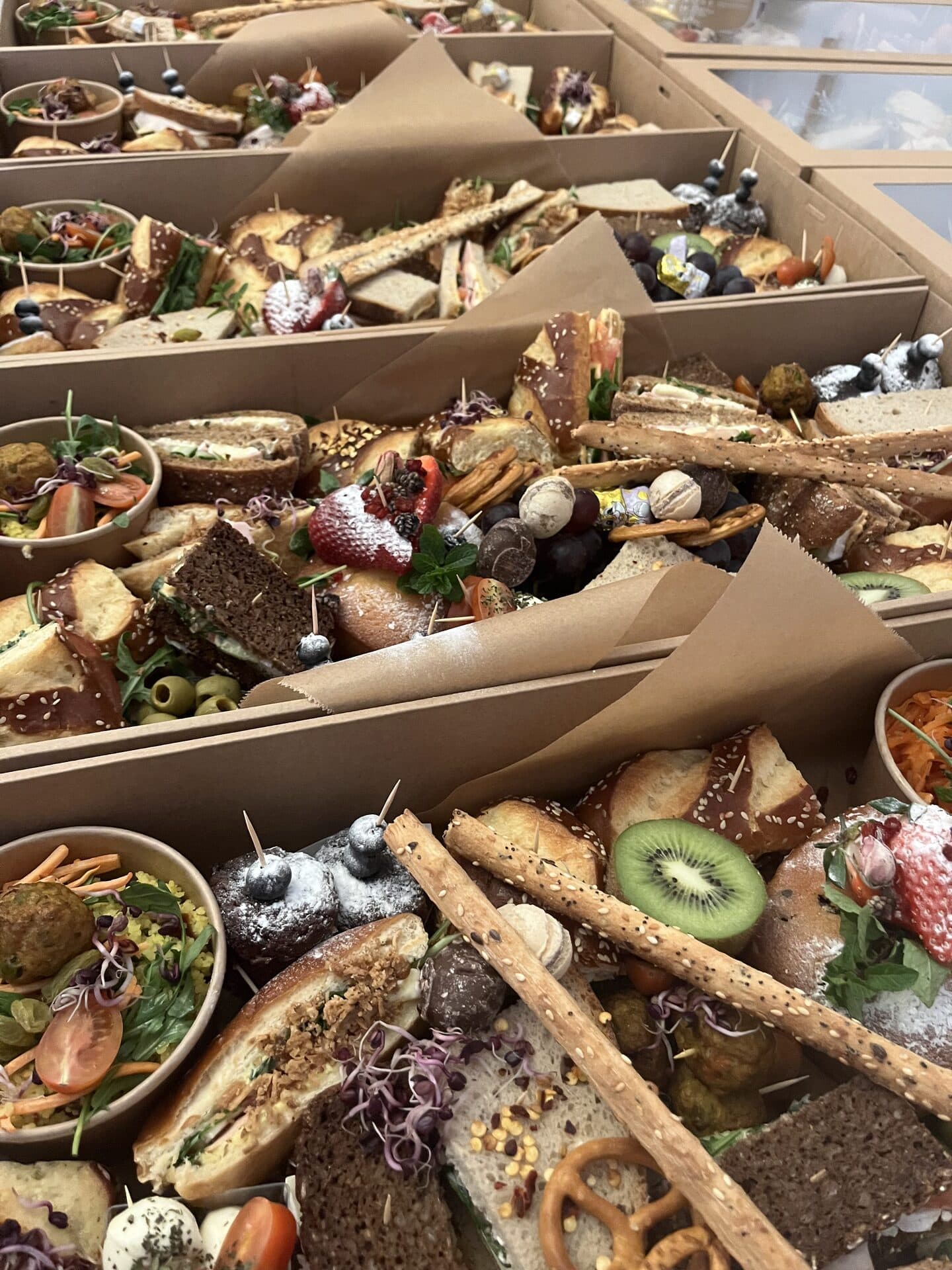 Foodbox mit essbaren Blüten, Kiwi und frischen Trauben